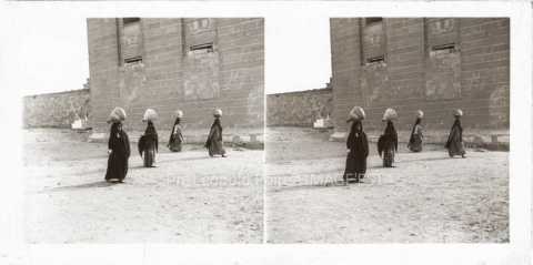 Femmes portant des vases