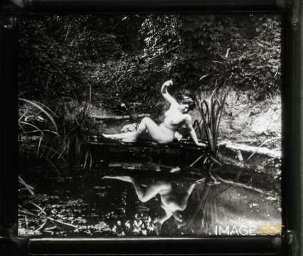 Femme nue près d'une mare