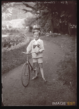 Enfant tenant une bicyclette (Le Val-d'Ajol)