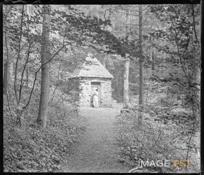 Femme devant une petite chapelle (Eulmont)