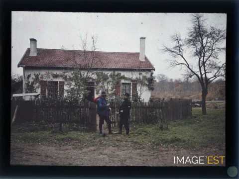 Deux hommes devant une maison