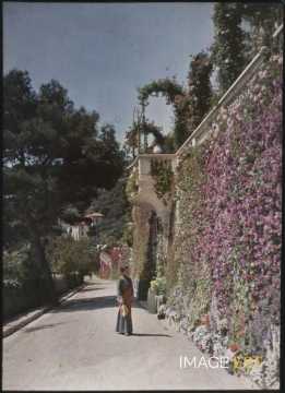 Femme près d'un mur fleuri (Beaulieu-sur-Mer)